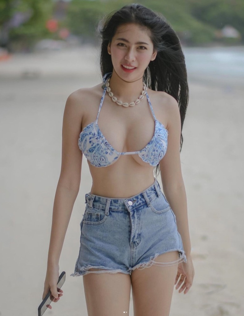 Thai model on the beach in denim shorts
